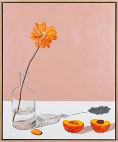 an orange flower in a glass vase next to two peaches