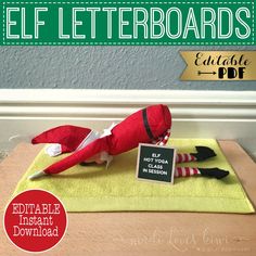 an elf laying on top of a towel next to a sign that says elf letterboards