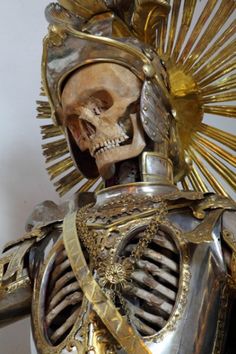 a skeleton dressed in gold and wearing a helmet with spikes on it's head