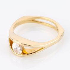 a yellow gold ring with a diamond on the top and bottom, set against a white background