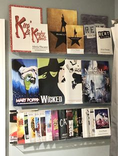 several books are arranged on the wall above a toilet