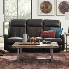 a living room scene with focus on the reclining couch and coffee table in the middle