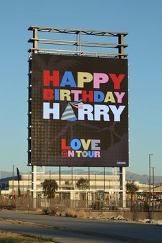 a large happy birthday sign on the side of a road