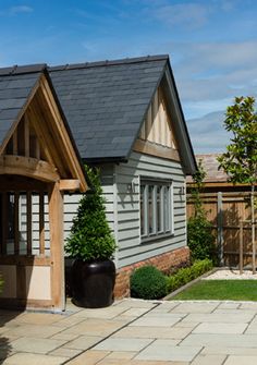 a small house with a black roof and wooden trim