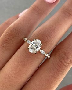 a woman's hand with a diamond ring on top of her finger and the bottom half