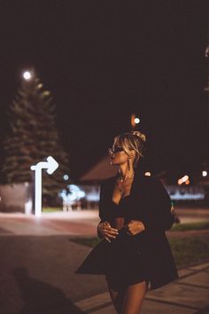 a woman walking down the street at night