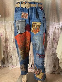 a mannequin wearing jeans with patches and designs on the sides, standing in front of a curtain