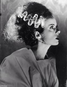 an old black and white photo of a woman with curly hair in her buns