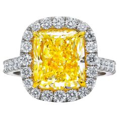 a fancy yellow diamond ring set in white gold with diamonds around the band and sidestones