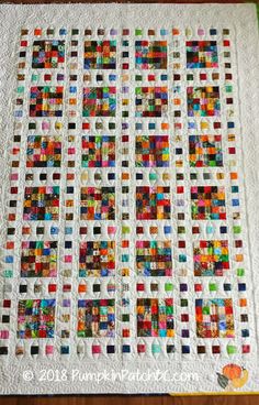 a quilted table topper with colorful squares on it