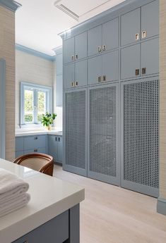 a kitchen with blue cabinets and white counter tops