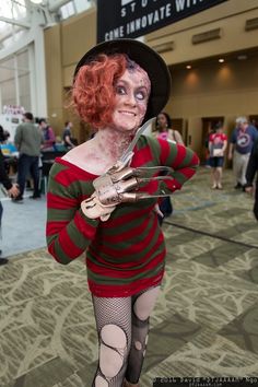 a woman dressed up as a zombie holding scissors in her right hand and looking at the camera