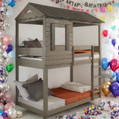 a wooden bunk bed with balloons and streamers in the background for a birthday party