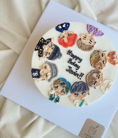 a birthday cake decorated with cartoon characters on top of a white sheet covered in frosting