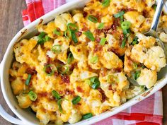 a white casserole dish filled with macaroni, cheese and green onions