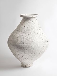 a white vase sitting on top of a table