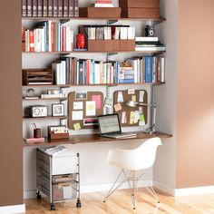 a laptop computer sitting on top of a desk in front of a bookshelf