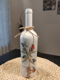 a glass bottle with birds painted on it