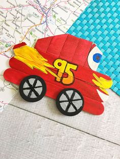 a wooden toy fire truck on top of a map with the letter p in it