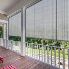 a porch with red benches and blinds on it