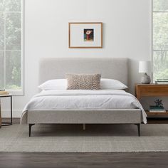 a white bed sitting in a bedroom next to a window