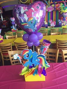 the table is set up with balloons and decorations