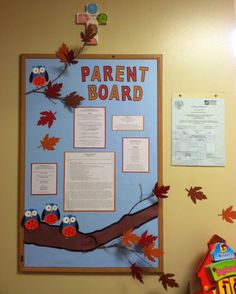 a bulletin board with leaves and owls on it next to a candy bar bag holder