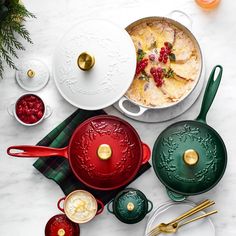 various dishes and utensils are arranged on a marble countertop, including one serving dish with raspberries