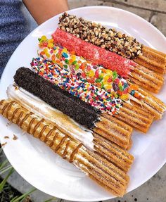 an assortment of desserts on a white plate with sprinkles and nuts