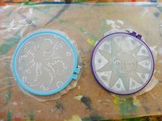 two cookie tins sitting on top of a table covered in frosting and plastic