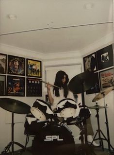 a woman with long hair playing drums in a room