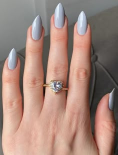 a woman's hand with a ring on it and a white manicured nail polish