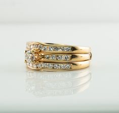 a gold ring with three diamonds on the top and two smaller ones in the middle