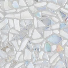 a close up view of white and silver mosaic tiles with different colors, shapes and sizes