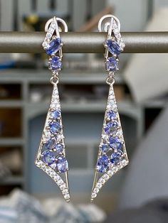 This is a fashion forward stylish earrings. The metal on this ring is 14K White gold plated sterling silver. The blue stones are beautiful oval cut 100% natural untreated Cornflower Blue Tanzanite from Tanzania. The accent stones are cubic zirconia (cz). Thai silver jewelries are well known for their craftsmanship and high silver content which keeps them from tarnishing through regular wear and tear. These types of rings are timeless in style and can be enjoyed & cherished by every generation. T Sapphire Tanzanite Jewelry With Matching Earrings, Oval Tanzanite Gemstone Earrings, Fine Jewelry Tanzanite Drop Earrings, Fine Jewelry Tanzanite Earrings In Sapphire Color, Fine Jewelry Sapphire Tanzanite Earrings, Sapphire Tanzanite Earrings Fine Jewelry, Tanzanite Drop Earrings For Anniversary, Silver Tanzanite Drop Earrings, Blue Tanzanite Drop Earrings