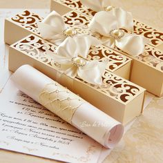 two boxes with bows on them sitting next to an envelope