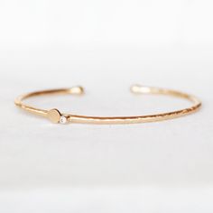 "Elegant, modern and sparkly! Hand forged out of 2mm 14k gold with a 2mm white diamond and a handmade petal. The cuff is not hollow, it is solid gold all the way through. The diamond and petal are set off-center on the cuff. I balled the ends with my torch. Simple and elegant, the perfect skinny cuff for every day wear! Diamond - 2mm I1 White, conflict-free Gold - 2mm 14k Cuff is 5.5\"L and has an opening of approximately 1\". It fits medium to small wrists and is slightly adjustable. If you wou Minimalist Diamond Cuff Bracelet For Anniversary, Minimalist Bangle With Single Cut Diamonds, Gold Cuff Bracelet With Single Diamond As Gift, Minimalist Bangle With Single Cut Diamonds For Gift, Minimalist Diamond Cuff Bracelet As A Gift, Recycled Gold Jewelry, Hand Jewelry Rings, Sweet Jewelry, Custom Bracelet