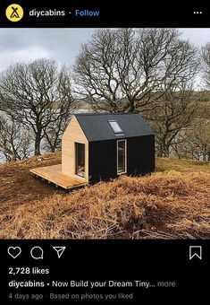 a small black house sitting on top of a dry grass covered hillside next to trees