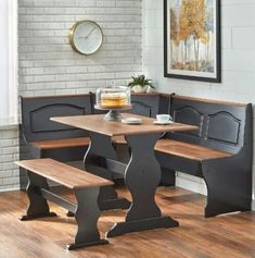 a kitchen table with benches and a clock on the wall