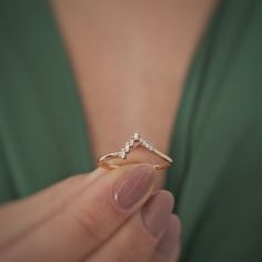 a woman holding a diamond ring in her hand