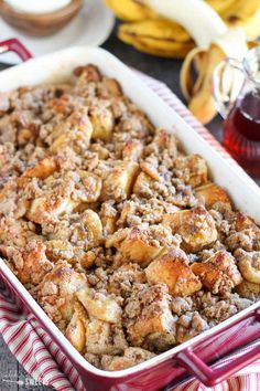 a casserole dish filled with bread and bananas on a red and white checkered cloth