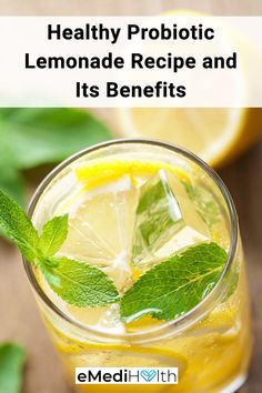 a glass with lemonade and mint in it on top of a table next to sliced lemons