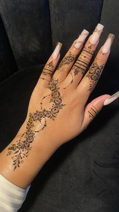 a woman's hand with henna tattoos on it