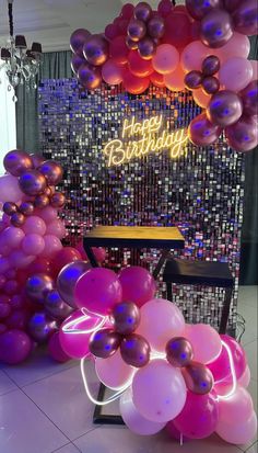 balloons and streamers are on the floor in front of a happy birthday sign at a party