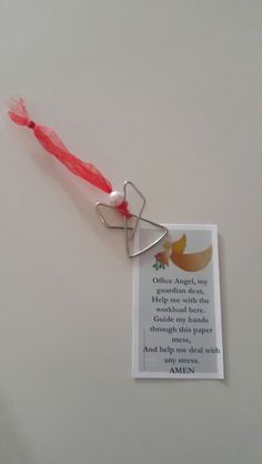 a keychain with a card attached to it on a white surface and a red string