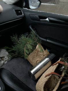 the back seat of a car is filled with christmas decorations and gifts, including pine cones