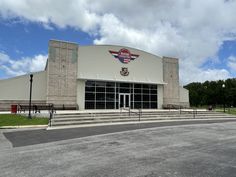 an empty parking lot in front of a large building with stairs leading up to it