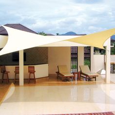 an outdoor area with chairs and tables under a white awning