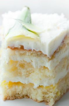 a piece of cake with white frosting and green leaves on top sitting on a plate