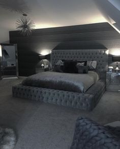 a large bed sitting in the middle of a bedroom next to two tables and lamps